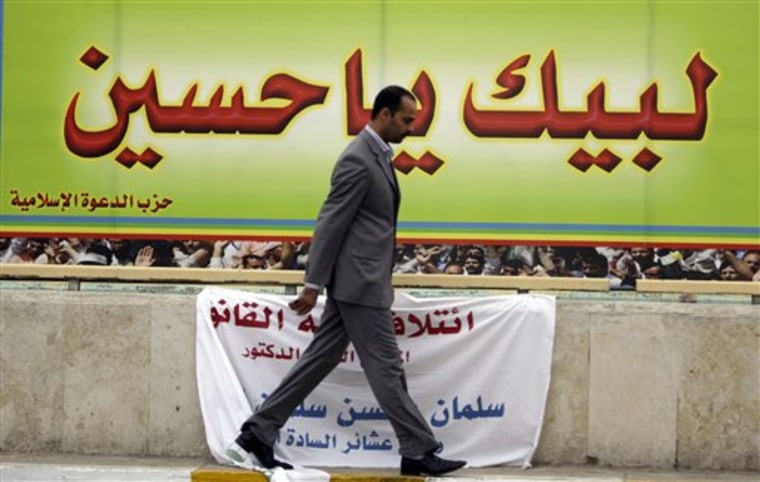 Iraqi man walks past a campaign poster for Shiite Dawa Party reading in Arabic "Oh, Hussein, here we come to your aid," in Baghdad, Iraq, on Feb. 16. Election campaigning is only stoking Iraq's political tensions. Thousands of campaign posters and banners around the city play to potentially explosive sectarian resentments, with Shiites pointing to Sunnis as loyal to Saddam Hussein or al-Qaida and Sunnis depicting Shiites as oppressing their community. 